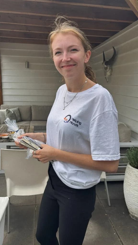 Helping Hands crewlid in branded shirt op locatie